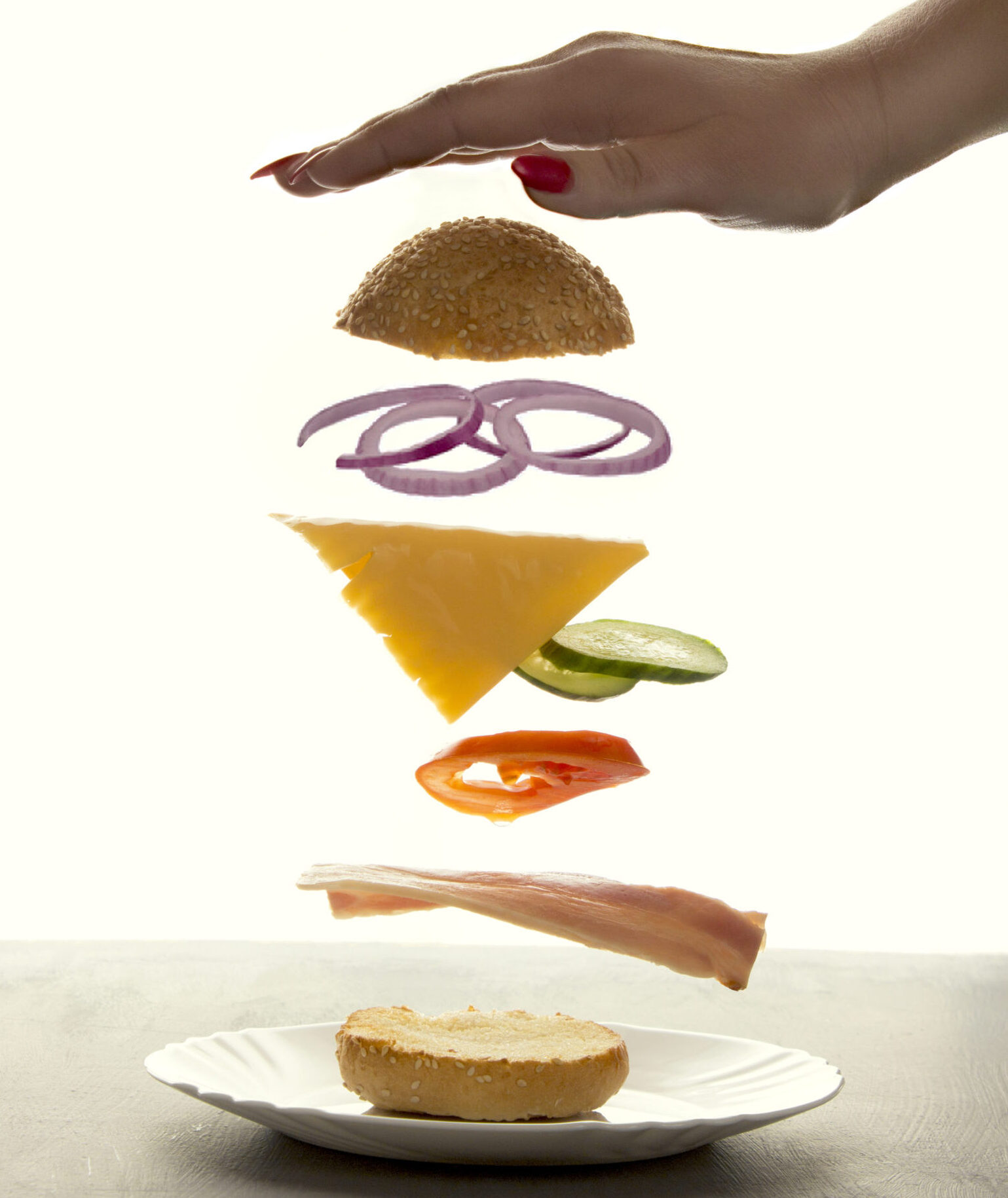 Sandwich floating in the air on a white background. The sandwich rises behind the woman's hand, the power of levitation.
